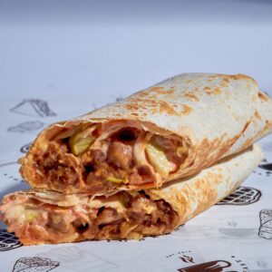 Appetizing burrito with meat and veggies, wrapped in tortilla and sliced open for a mouth-watering view.